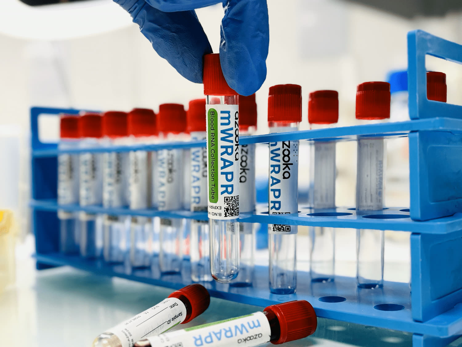 A rack of red-capped mWRAPR blood collection tubes